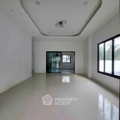 Spacious modern living room with large windows and sleek ceiling design