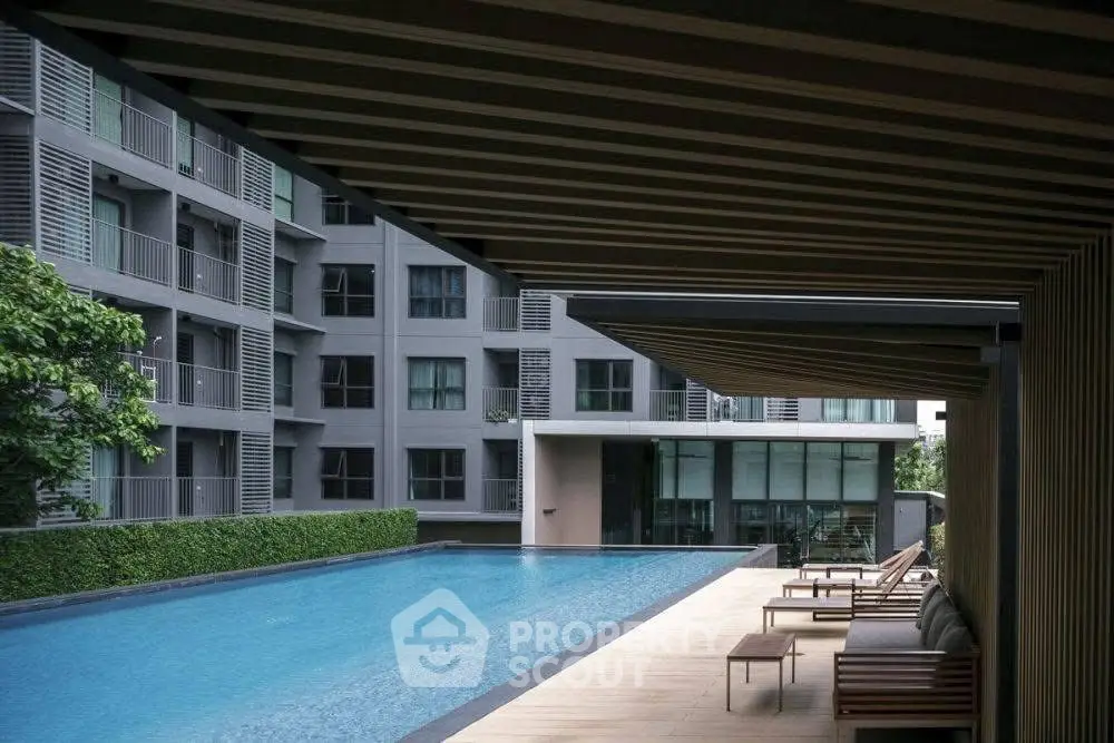 Luxurious apartment complex with modern poolside view and elegant architecture.