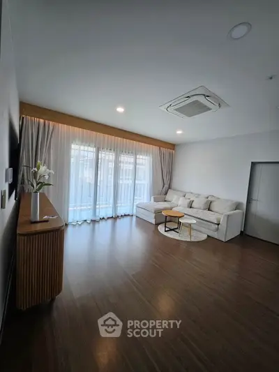 Spacious modern living room with elegant decor and large windows for natural light.