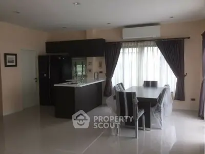 Modern dining area with sleek kitchen and large window, perfect for family gatherings.