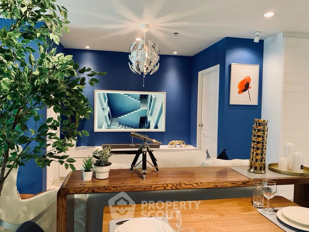 Modern living room with blue accent wall, stylish decor, and telescope for a chic urban lifestyle.