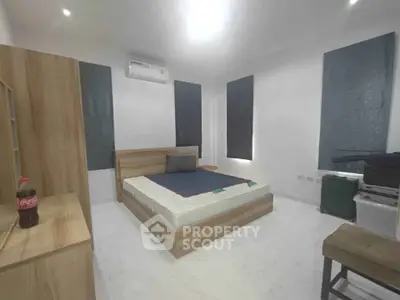 Modern bedroom with minimalist design and air conditioning, featuring a cozy bed and sleek furniture.