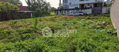 Spacious plot of land with lush greenery, ideal for development in a serene neighborhood.