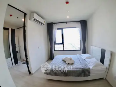 Modern bedroom with large window and stylish decor in a contemporary apartment.