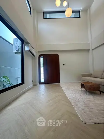 Spacious modern living room with high ceilings and large windows for natural light.
