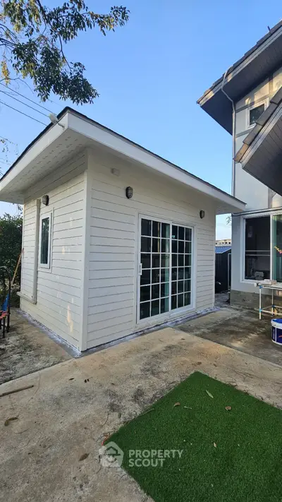 Charming backyard studio with modern sliding doors and sleek exterior design