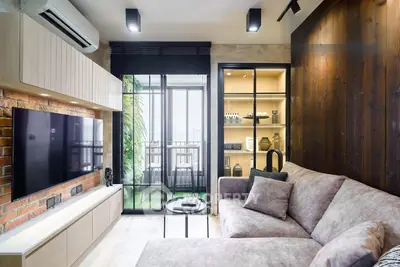Modern living room with stylish decor and large glass doors leading to a balcony with city view.