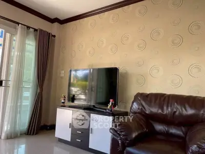 Cozy living room with modern TV setup and elegant leather sofa.