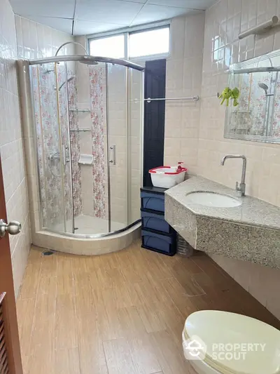 Modern bathroom with corner shower and sleek granite countertop