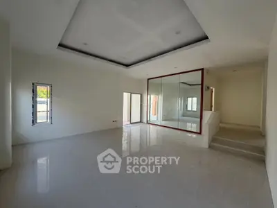 Spacious modern living room with large windows and glossy flooring