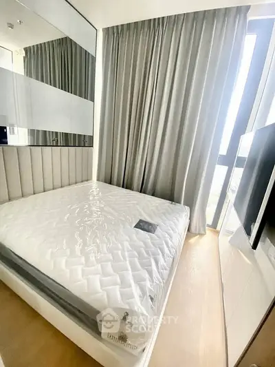 Modern bedroom with large window and stylish decor in a high-rise apartment.