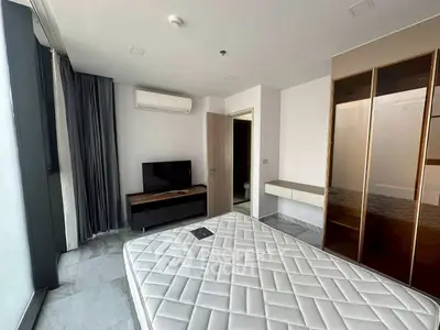 Modern bedroom with sleek design, featuring a large window, air conditioning, and stylish furniture.