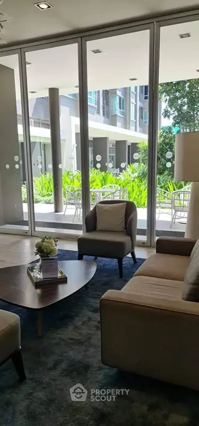 Modern living room with large windows overlooking lush garden in luxury apartment.