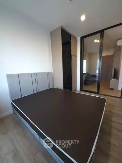 Modern bedroom with sleek design and ample natural light, featuring a stylish bed and built-in wardrobe.