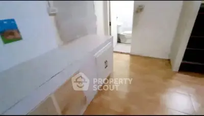 Spacious interior with tiled flooring and bathroom access, ideal for renovation.
