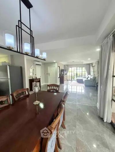 Spacious open-plan living and dining area with elegant lighting and modern furnishings.