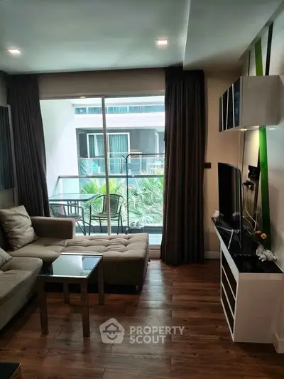 Modern living room with balcony view, featuring stylish furniture and natural light.
