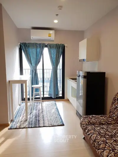 Modern living room with balcony, stylish decor, and natural light in urban apartment.