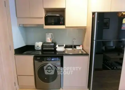 Compact modern kitchen with appliances including washing machine and microwave, ideal for urban living.