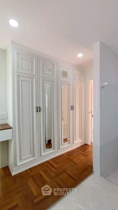 Spacious bedroom with elegant built-in wardrobe and hardwood flooring