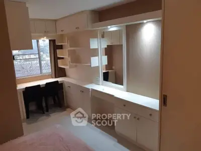 Modern bedroom with built-in desk and storage, featuring sleek design and ample natural light.