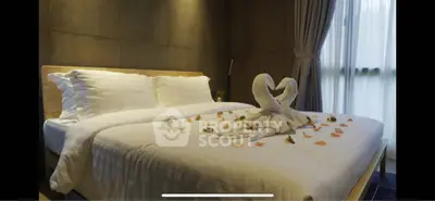 Luxurious bedroom with elegant decor and soft lighting, featuring a beautifully made bed with swan towel art.