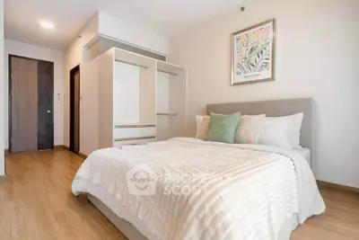 Spacious bedroom with modern decor and ample natural light, featuring a cozy bed and stylish artwork.