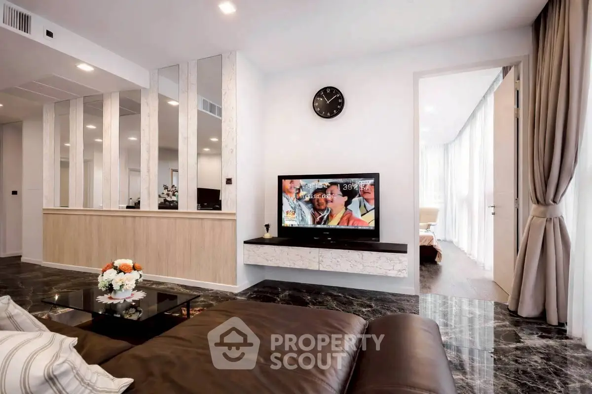 Modern living room with sleek design, marble flooring, and wall-mounted TV for luxurious comfort.