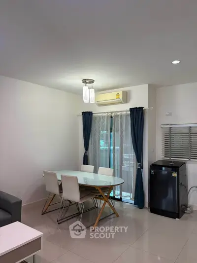 Modern dining area with sleek table, chairs, and air conditioning, perfect for stylish living.