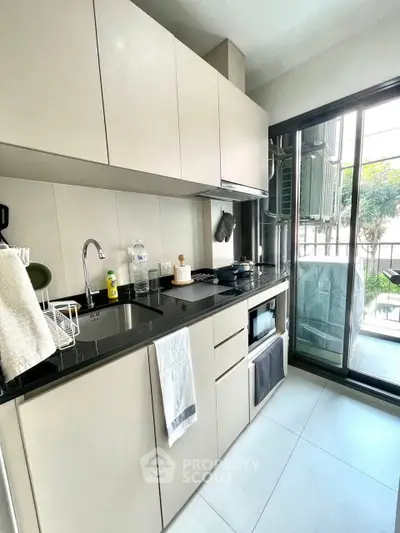 Modern kitchen with sleek cabinetry and balcony view