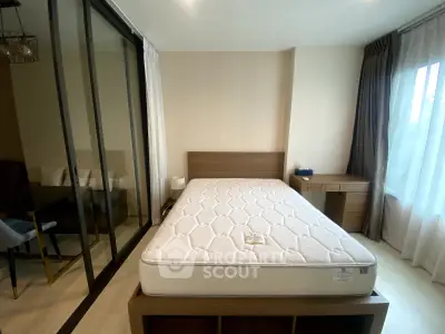 Modern bedroom with large window and stylish furniture in a cozy apartment.