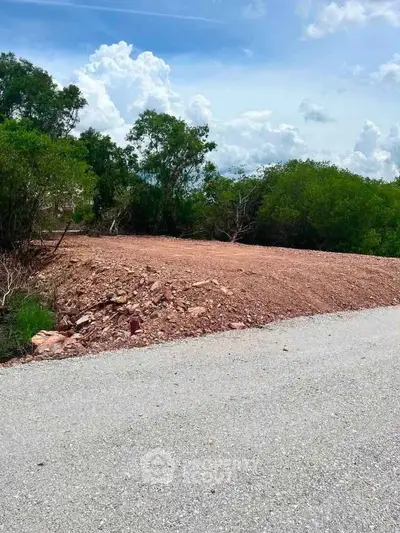 Vacant land plot with clear skies and lush greenery, ideal for development opportunities.