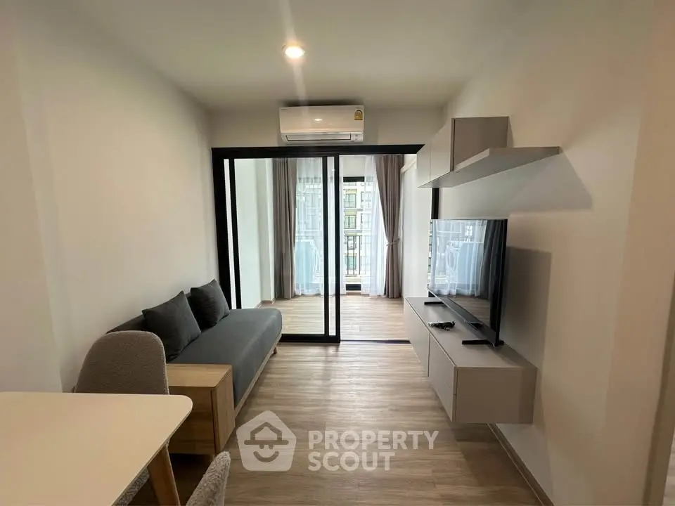 Modern living room with sleek furniture and balcony view in a stylish apartment.