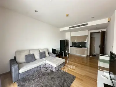 Modern living room with open kitchen and cozy sofa in a stylish apartment.