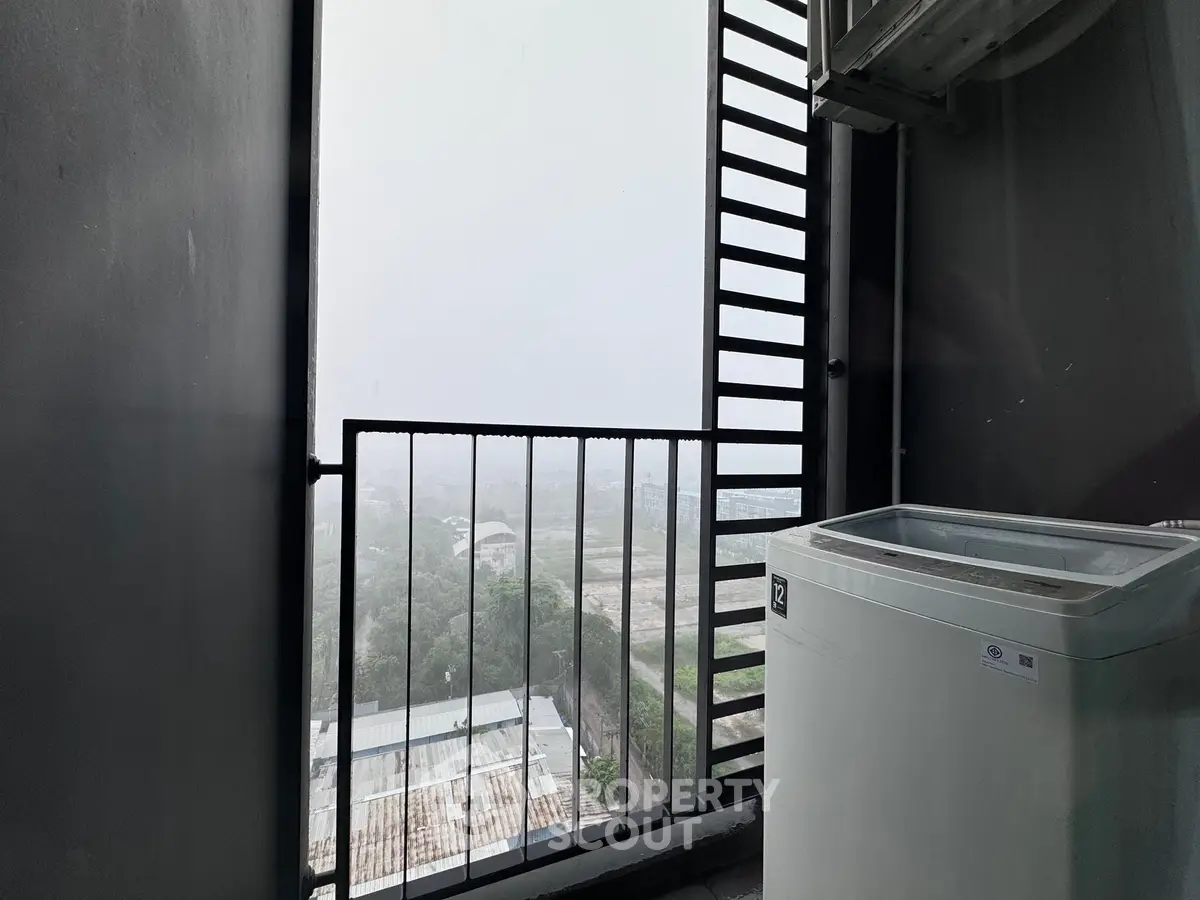Modern balcony with washing machine and panoramic view of cityscape.