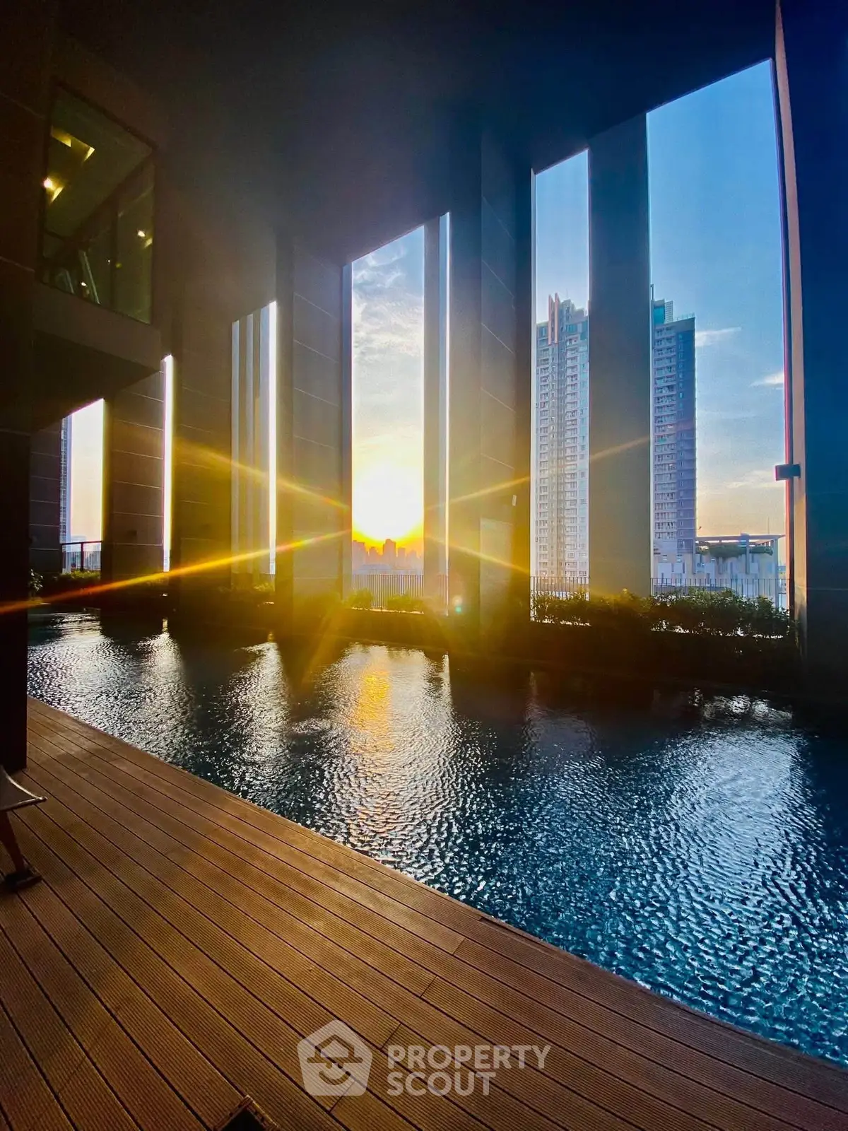 Luxurious high-rise pool with stunning sunset city view, perfect for urban living.