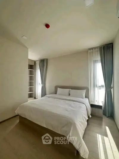 Spacious bedroom with natural light and modern design in a stylish apartment.
