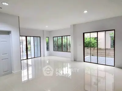 Spacious modern living room with large windows and glossy tile flooring