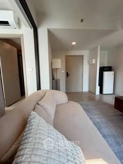 Modern living room with cozy beige sofa and stylish decor in a contemporary apartment.