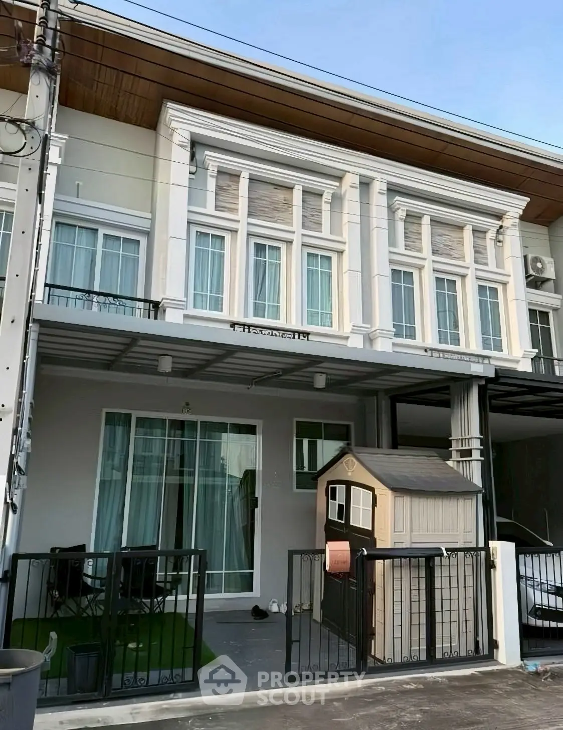 Modern townhouse exterior with balcony and small garden area, perfect for family living.