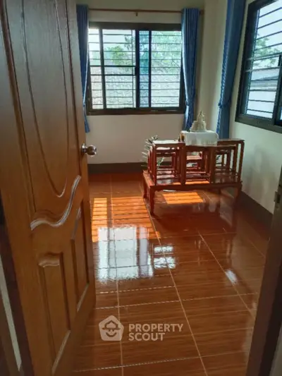 Cozy room with wooden furniture and large windows, perfect for natural light lovers.