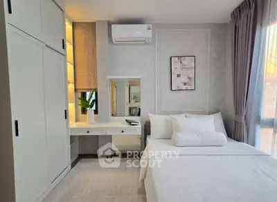 Modern bedroom with sleek white furniture and cozy decor