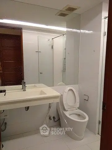 Modern bathroom with sleek fixtures and large mirror in a contemporary home.