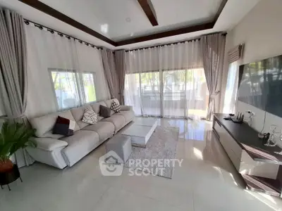 Spacious modern living room with elegant decor and large windows offering natural light.