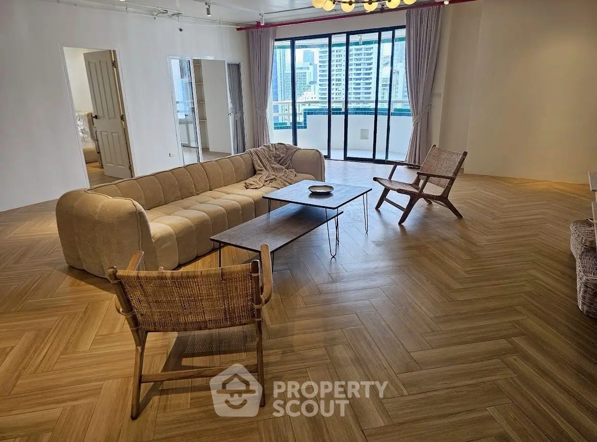 Spacious living room with modern decor and city view balcony.