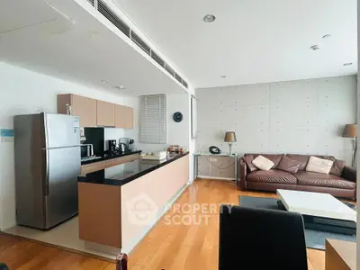 Modern open-layout kitchen and living room with sleek design and hardwood floors.