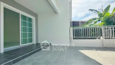 Spacious modern patio with sliding glass doors and tiled flooring, perfect for outdoor relaxation.