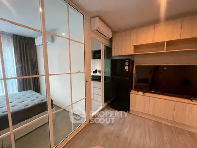 Modern apartment interior with glass partition, cozy bedroom, and sleek living area.