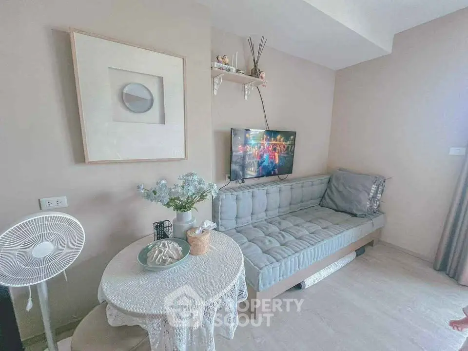 Cozy living room with modern decor and wall-mounted TV, perfect for relaxation.