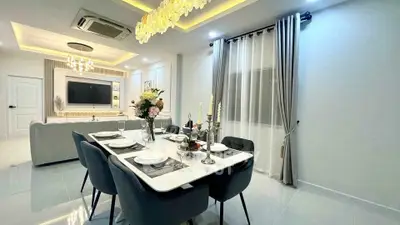 Luxurious dining area with elegant table setting and modern lighting in a spacious open-plan living room.